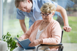 Elder in wheelchair reading book